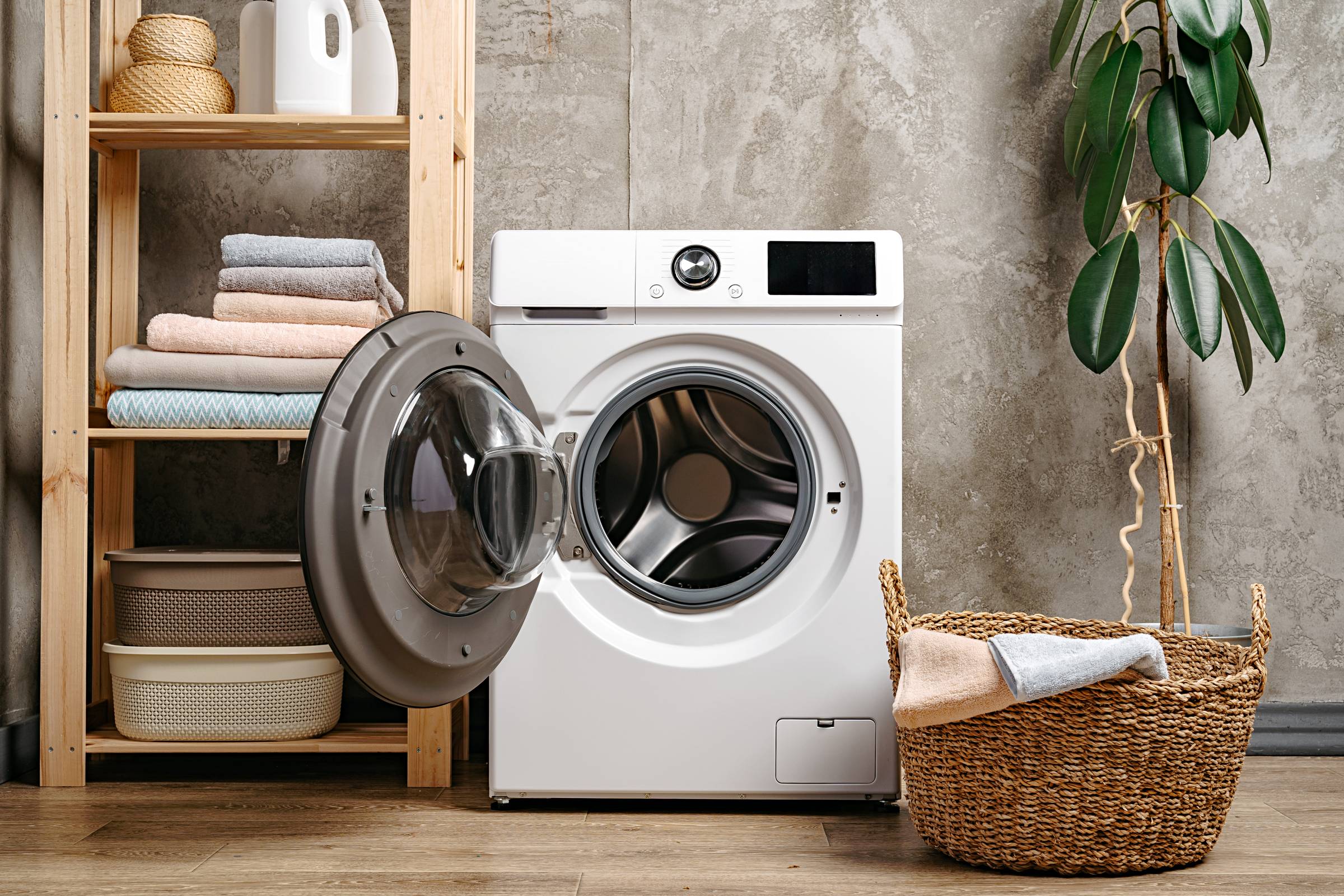 Laundry room interior with  washing machine near gray grunge wall close up